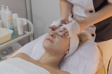 Profesyonel güzellik bir güzellik salonunda bir kadın için prosedür yapar.