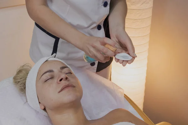 Professionelle Kosmetikerin macht den Eingriff für eine Frau in einem Schönheitssalon. — Stockfoto