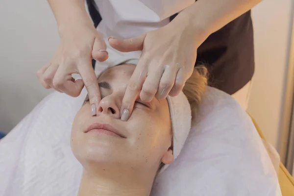 Professionelle Kosmetikerin macht den Eingriff für eine Frau in einem Schönheitssalon. — Stockfoto