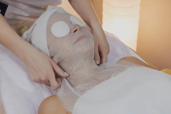 Professional beautician does the procedure for a woman in a beauty parlor.