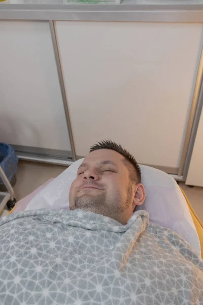 Homem bonito no procedimento de depilação em um salão de beleza . — Fotografia de Stock