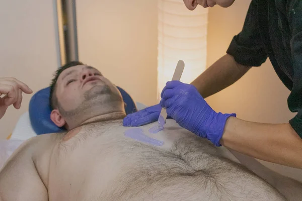 Homem bonito no procedimento de depilação em um salão de beleza . — Fotografia de Stock