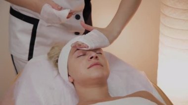 Bir kadın güzellik salonunda özel mendiller ile temizlenir.