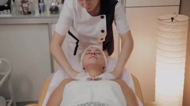 Bir kadın güzellik salonunda özel mendiller ile temizlenir.