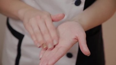 Profesyonel güzellik ellerine krem uygular.