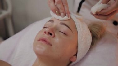 Bir kadın güzellik salonunda özel mendiller ile temizlenir.