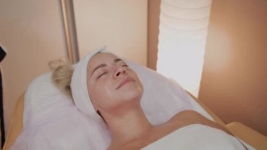 Bir kadın güzellik salonunda özel mendiller ile temizlenir.