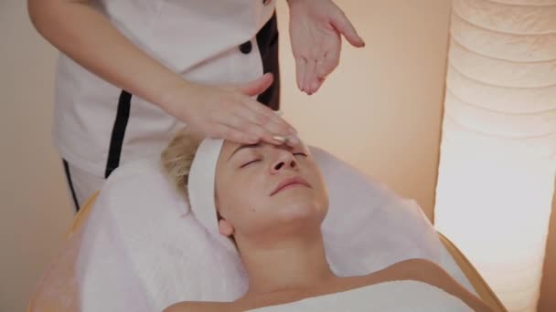 Mujer haciendo masaje facial en el salón de spa . — Vídeos de Stock