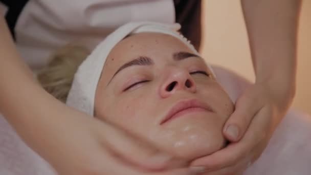 Kadın Spa salonunda yüz masajı yapıyor. — Stok video