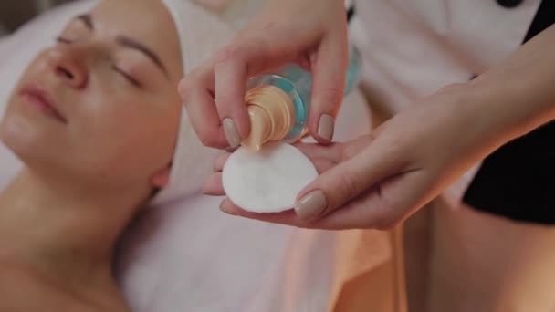 Beautician applies lotion on cotton pad. — Stock Video