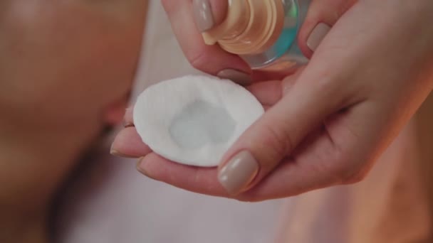 Kosmetolog applicerar lotion på bomull pad. — Stockvideo