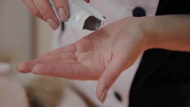 Esteticista profissional aplica creme em suas mãos . — Vídeo de Stock