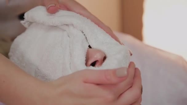Mujer en el procedimiento en la esteticista con una toalla en la cara . — Vídeos de Stock