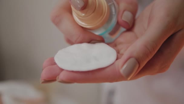 Schoonheidsspecialiste past lotion op wattenschijfje. — Stockvideo