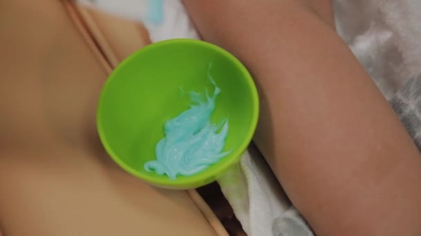Beautician stirs a face mask in a container. — Stock Video