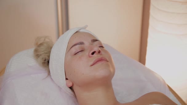 Επαγγελματική αισθητικός εφαρμογή μάσκα με βούρτσες στο πρόσωπο της γυναίκας. — Αρχείο Βίντεο