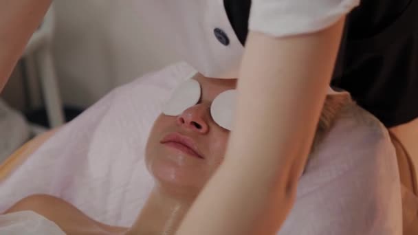 Esthéticienne professionnelle préparant le visage pour appliquer le masque . — Video