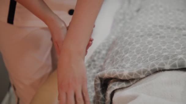 Menina muito bonita recebe uma massagem em suas mãos no salão de spa . — Vídeo de Stock