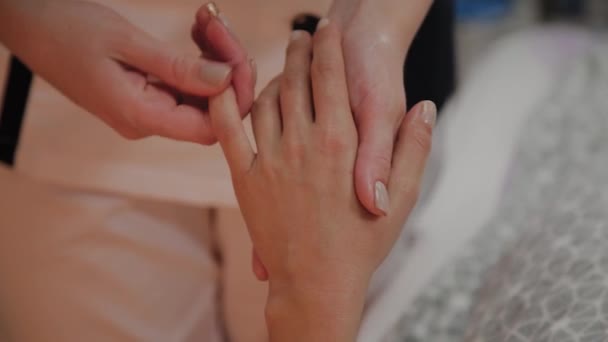 Sehr schönes Mädchen bekommt eine Massage an den Händen im Wellnesssalon. — Stockvideo
