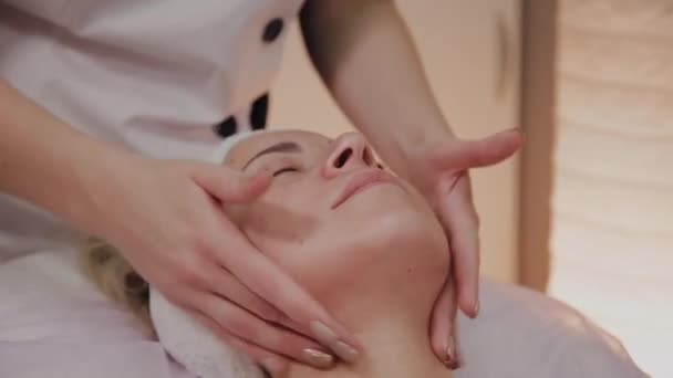 Estetista applica la crema sul viso della donna . — Video Stock