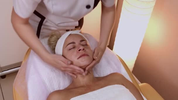 Mulher fazendo massagem facial no salão de spa . — Vídeo de Stock