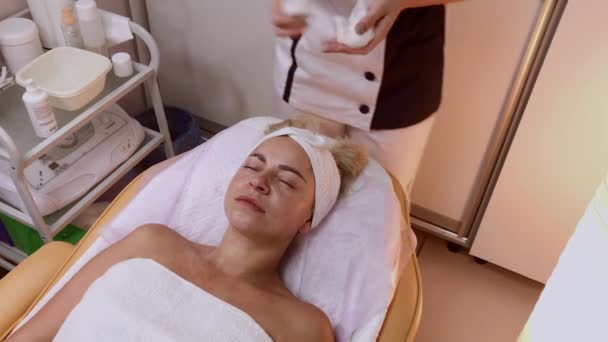 Mujer haciendo masaje facial en el salón de spa . — Vídeo de stock