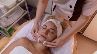 Kadın Spa salonunda yüz masajı yapıyor.