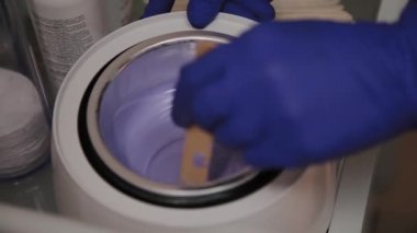 Profesyonel güzellik epilasyon için balmumu karıştırır.