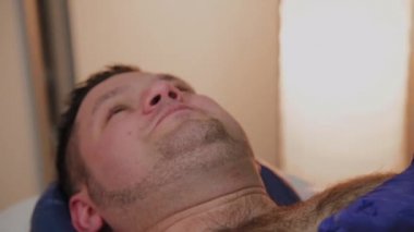 Profesyonel güzellik bir güzellik salonunda bir adam için ağda yapar.