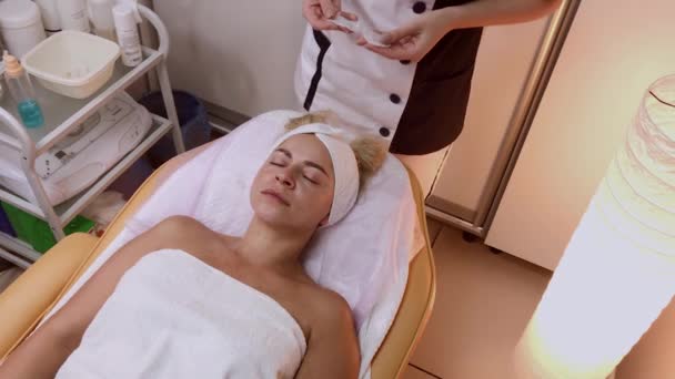 Vrouw doet gezicht massage in de spa salon. — Stockvideo