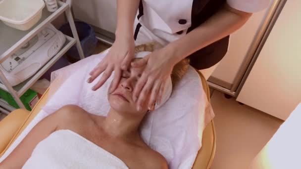 Vrouw doet gezicht massage in de spa salon. — Stockvideo