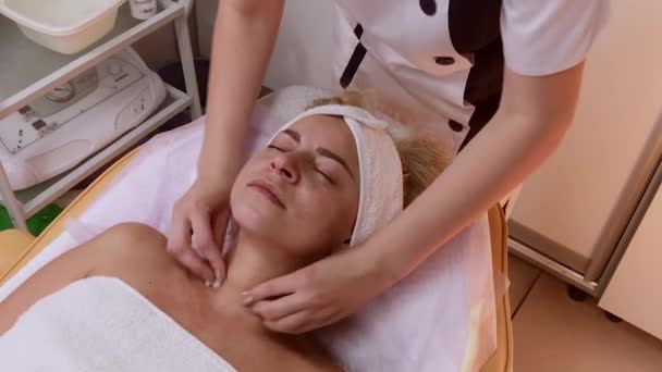 Mujer haciendo masaje facial en el salón de spa . — Vídeo de stock