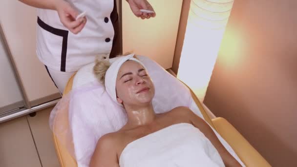 Professionell kosmetolog förbereder ansiktet för applicering mask. — Stockvideo