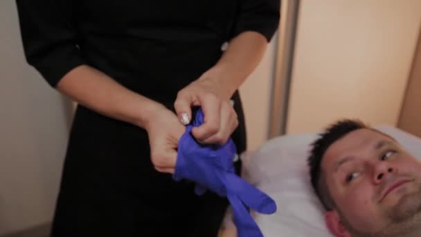 Beautician işlemden önce lastik eldiven koyar. — Stok video