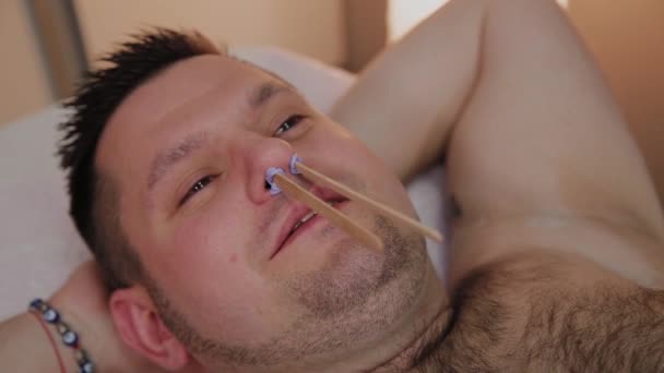 Професійний косметолог робить восковий на носі чоловіка . — стокове відео