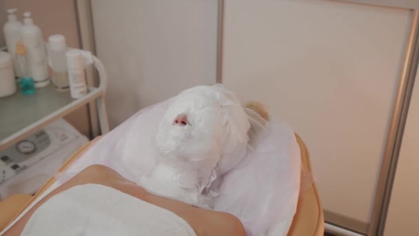 Cosmetische procedure. Vrouw in schoonheidssalon met masker op haar gezicht. Gezichtsmasker toepassing. — Stockvideo