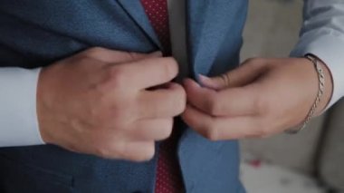 İşadamı parlak bir odada ceketini bağladı.