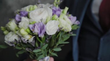 Kanepede bir buket ile genç damat.