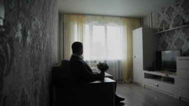 Kanepede bir buket ile genç damat.