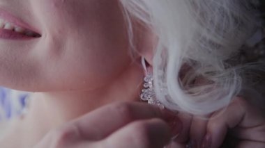 Güzel gelin pencereden küpe kapatır.