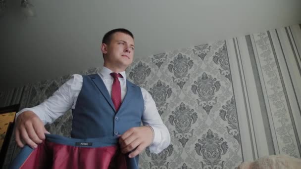 Hombre de negocios sujeta su chaqueta en una habitación luminosa . — Vídeos de Stock