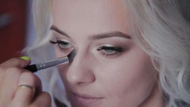 Blonde Mädchen machen professionelles Make-up. — Stockvideo