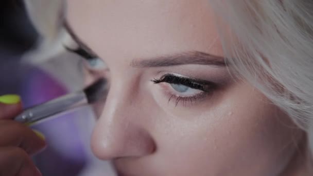 Blond flicka gör professionell makeup. — Stockvideo
