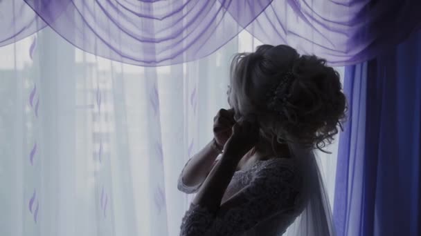 Bella sposa chiude gli orecchini dalla finestra . — Video Stock