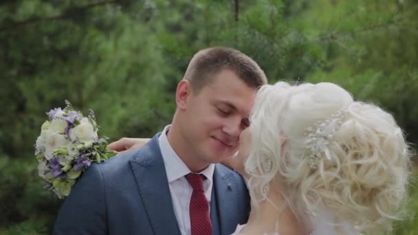 Très belle mariée et marié se tiennent la main et se câlinent dans la forêt . — Video