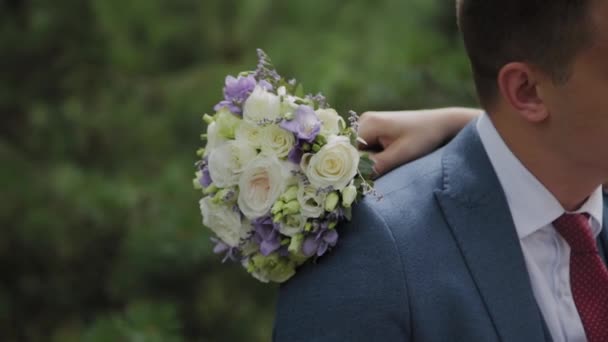 Πολύ όμορφη νύφη και ο γαμπρός κρατούν τα χέρια και αγκαλιάζονται στο δάσος. — Αρχείο Βίντεο