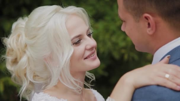 Beautiful groom and blonde bride by the creek in the forest. — Stock Video