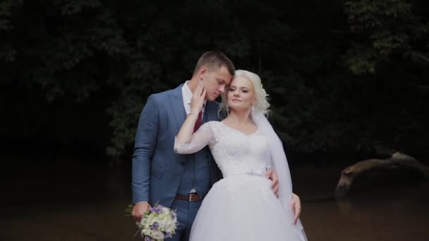 Bellissimo sposo e sposa bionda vicino al torrente nella foresta . — Video Stock