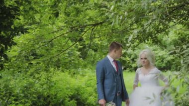 Çok güzel gelin ve damat ormanda el ele tutuşup kucaklaşın.