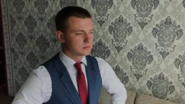 İşadamı parlak bir odada ceketini bağladı.